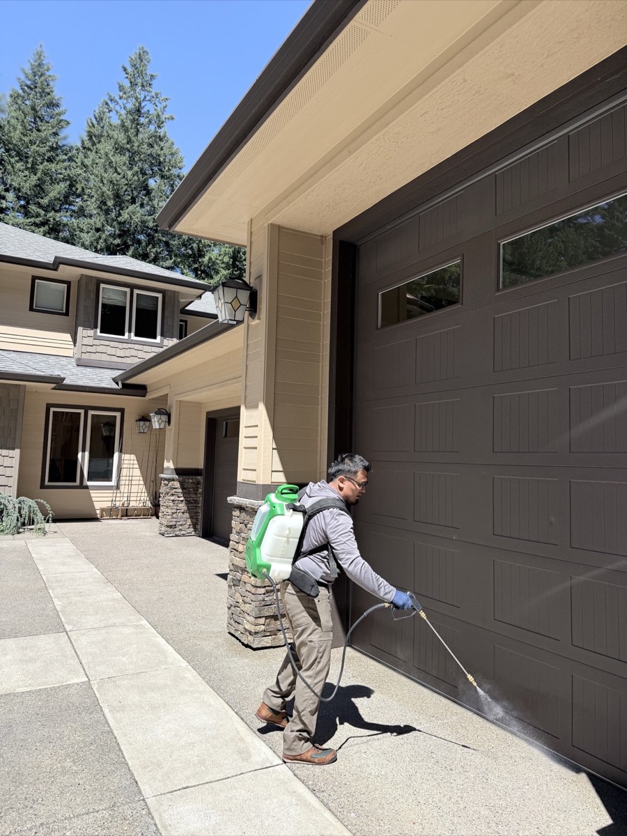 Affordable Pest Pros technician treating a garage threshold and exterior perimeter