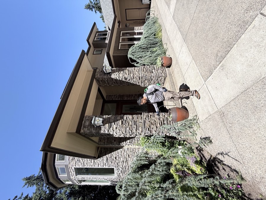 Affordable Pest Pros technician performing exterior perimeter pest control at a Vancouver-area home